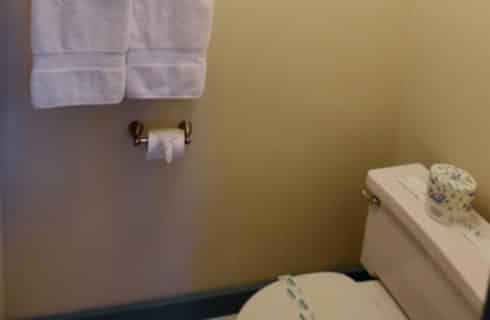 Bathroom with a towel rack holding soft white towels.